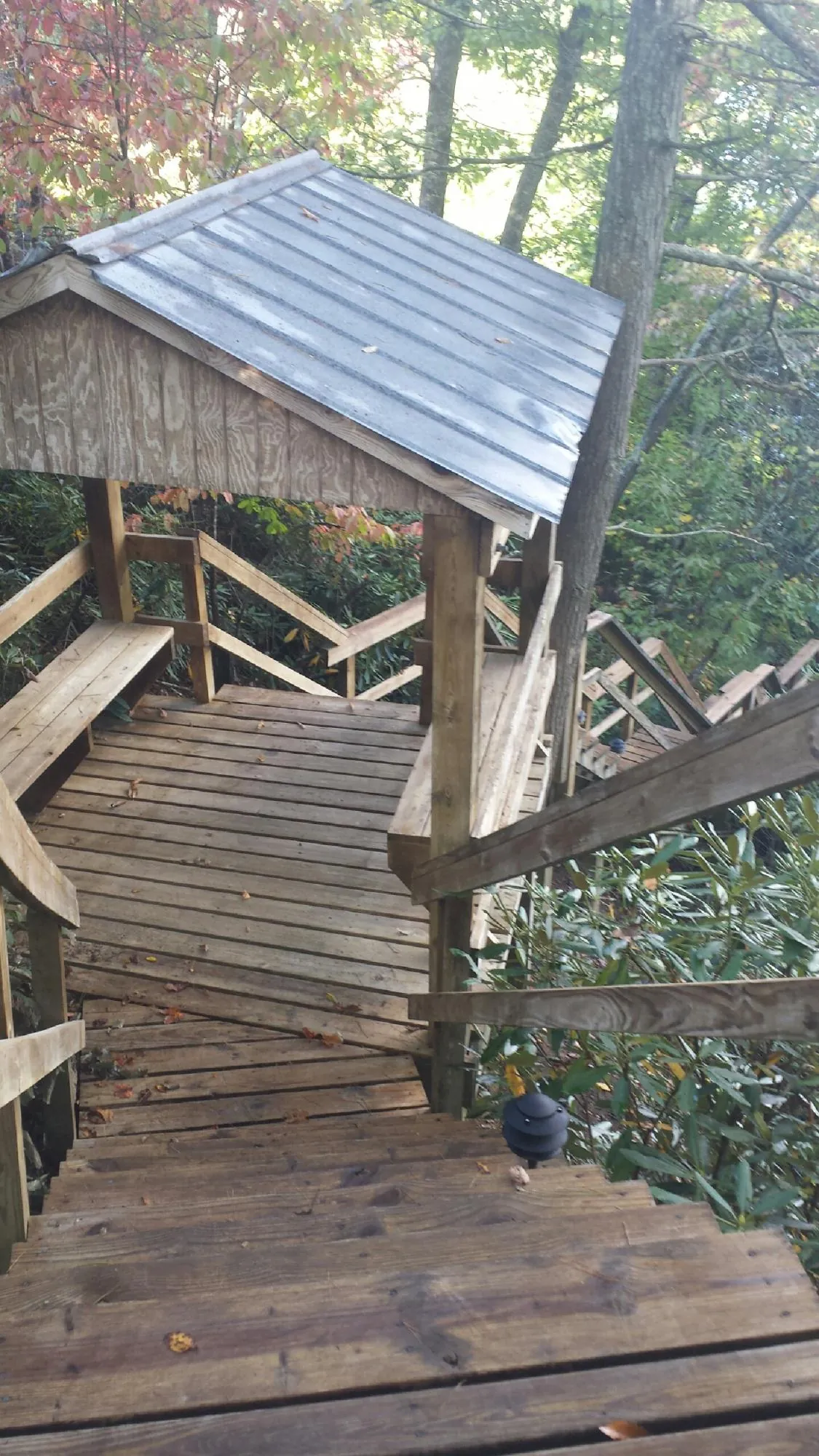 Metal roofed shelter over wooden steps on a wooded walkway — Skylight Repair & Installation work by our crew in Oakdale